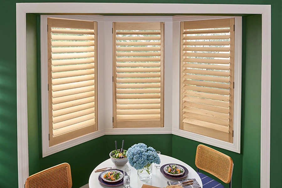 Choose window treatments that fit within the window frames for bay windows. faux wood shutters on bay windows