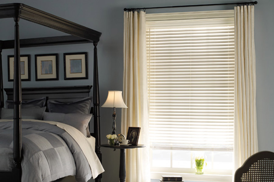 White window blinds with white curtains on a bedroom window