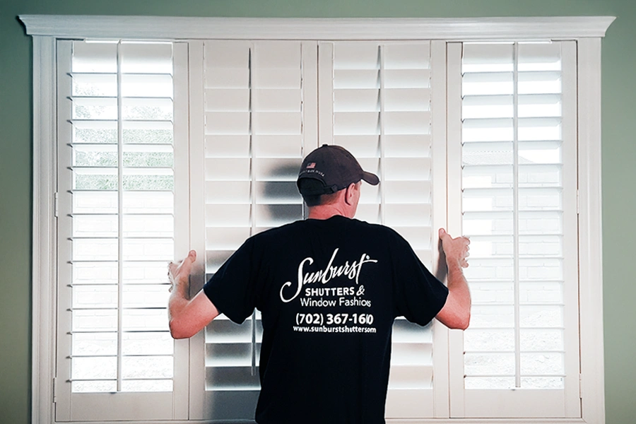 Need to remove shutters during a window replacement? Call your trusted window treatment installer. A Sunburst Shutters employee installing Polywood shutters on a window