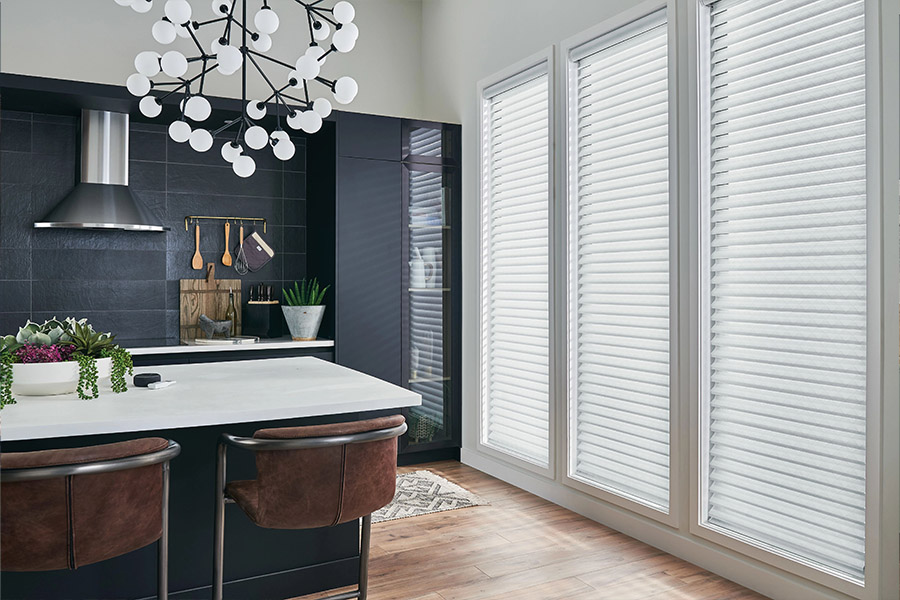 White sheer shades and a modern light fixture in a gray and white kitchen