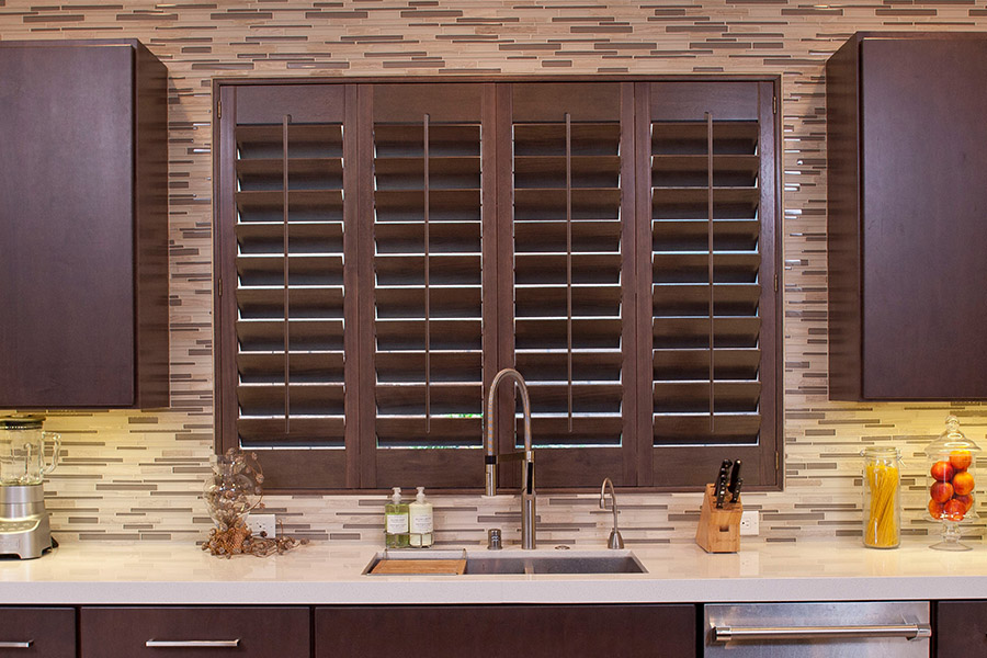 Dark wood plantation shutters on a kitchen window