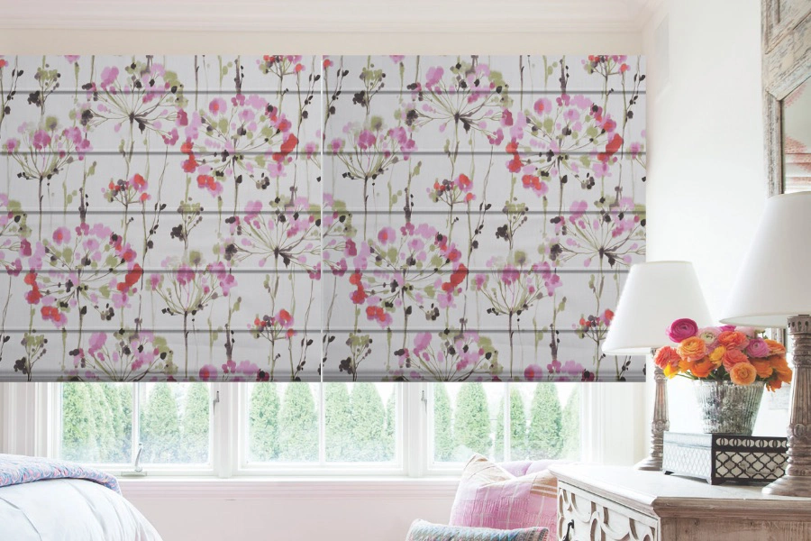 Stylish window shades hang above casement window cranks and add color to your room. Pink floral Roman shades on casement bedroom windows