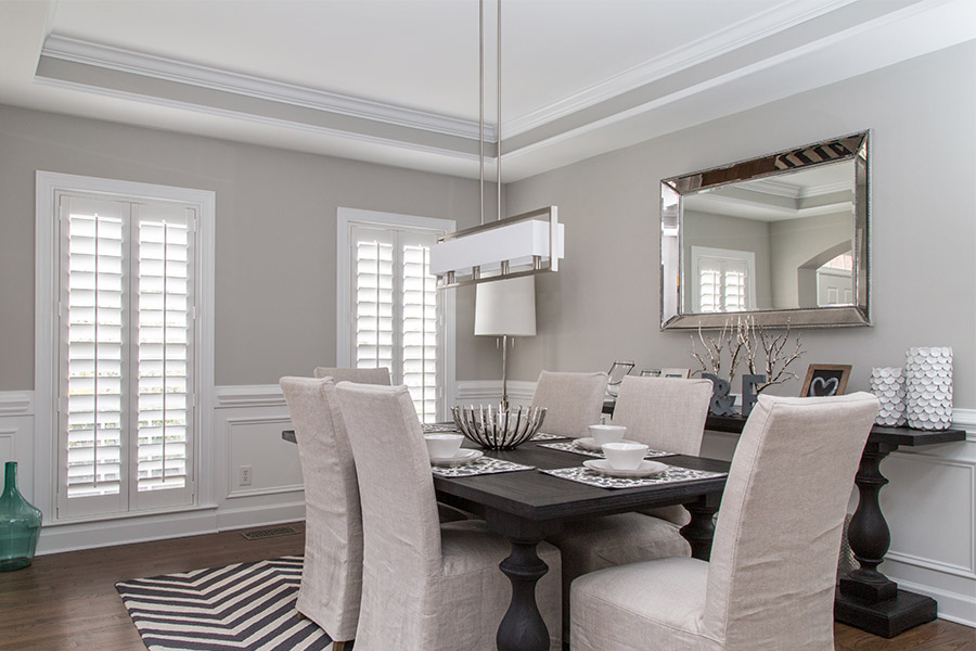 White Polywood shutters on windows in an elegant dining room