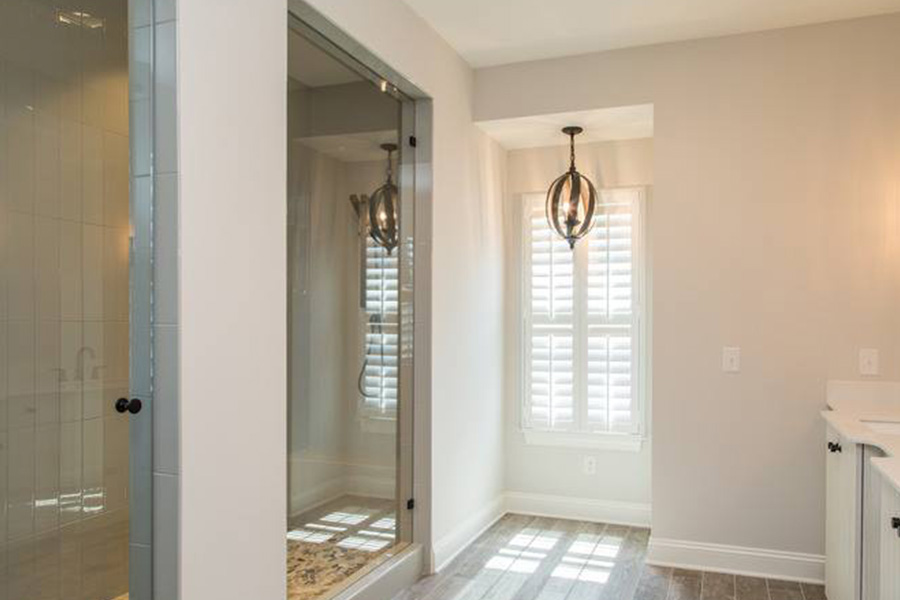 Polywood shutters on a window in a brown tile shower