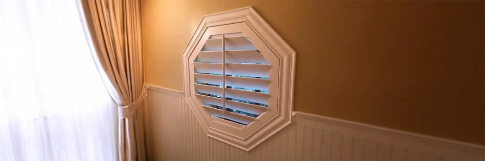 White shutter octagon window in a living room corner
