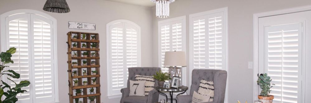 Photo credit: Whimsy Girl Design White Polywood shutters on several windows in a stylish living room