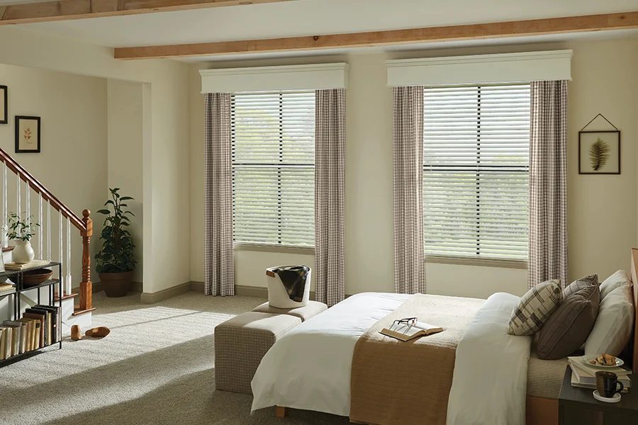 Wood blinds with drapes in a bedroom setting