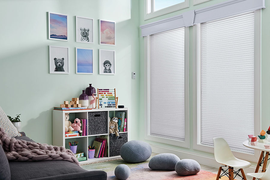 If your nursery or playroom has tall windows, install motorized shades to make it easy for the whole family to operate them. White sheer shades on tall playroom windows