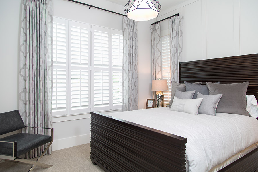 Polywood shutters bring daylight to help you wake up for the day. Bedroom with a lot of natural light from white Polywood shutters.