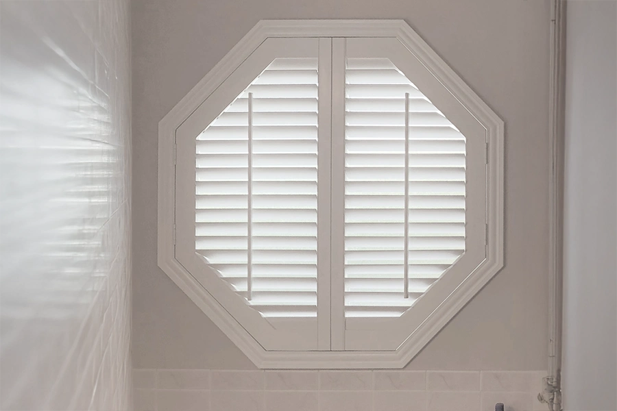 Large white shutter window in special shape of octagon within a bathroom