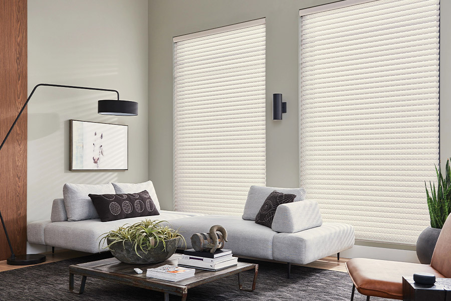 Ask your window treatment installer about safe, easy window treatment operating systems. White sheer shades on large living room windows