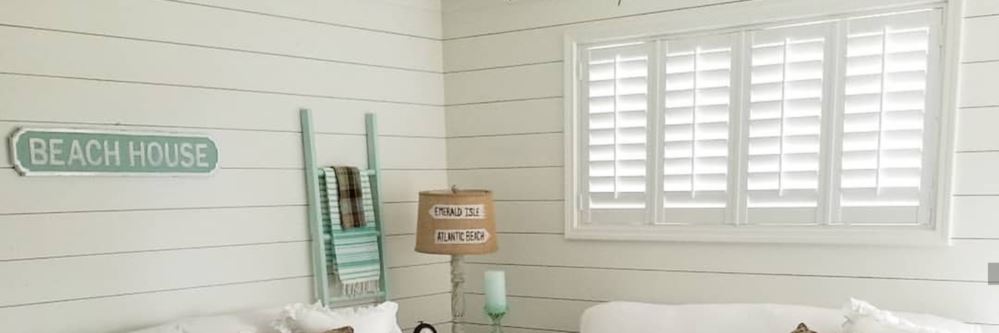 photo credit: @happydayfarms Cozy living room with shiplap and white Polywood shutters above a couch.