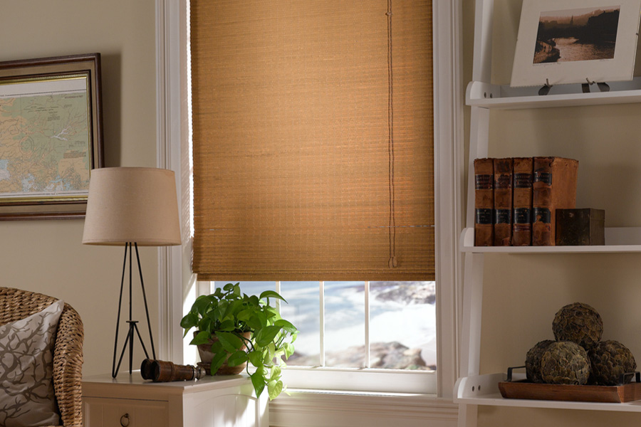 Woven fiber shades go well with neutral colors to create a calm getaway. Tan Roman shade in a small living room window.