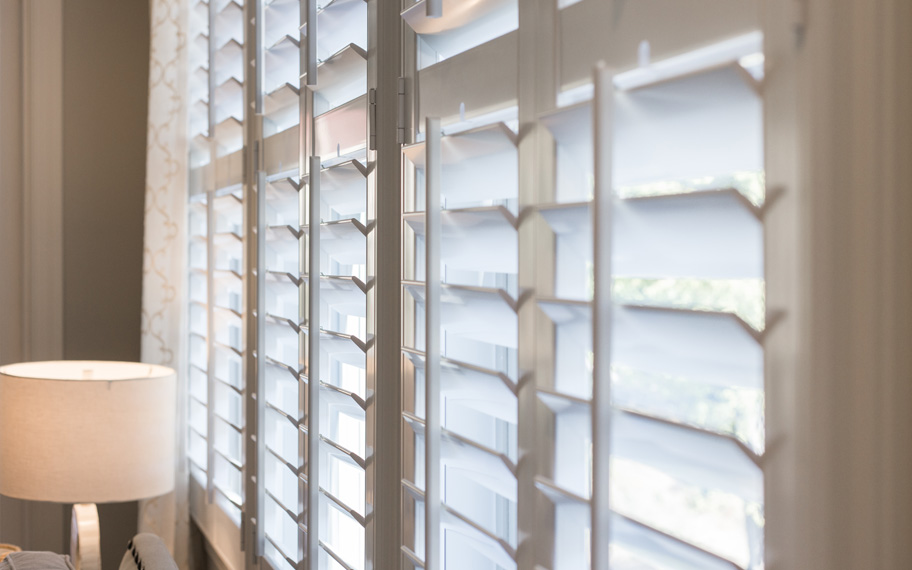 Skylight windows and white Polywood shutters are a true match for your home. Close up of white polywood shutters.