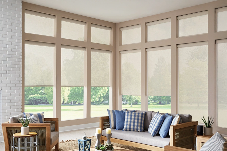 Beige solar shades on tall windows in a living room