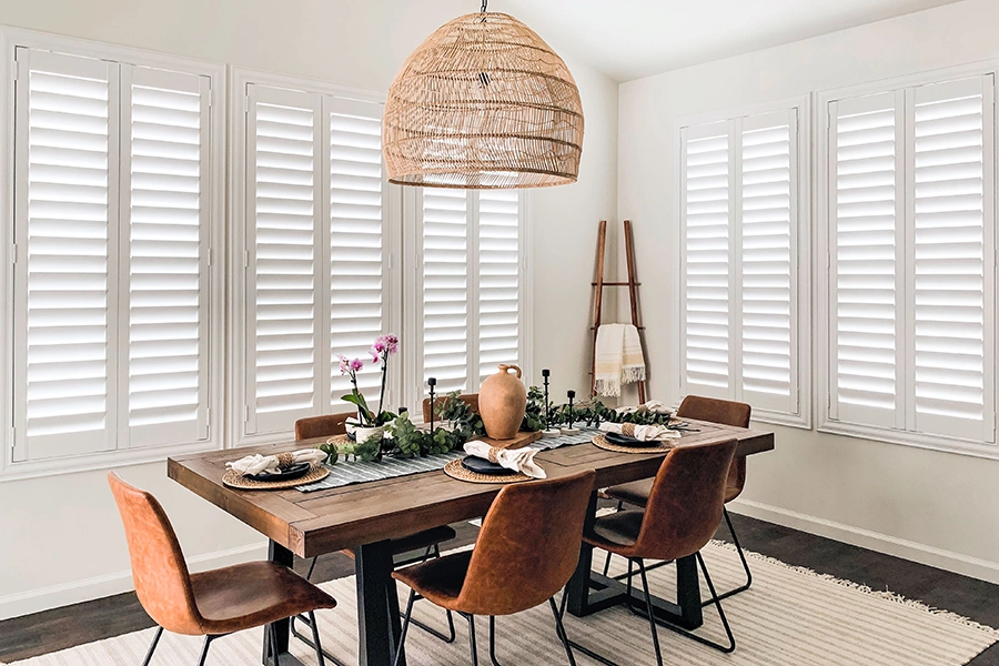 Control the light levels in your mid-century modern home with versatile interior shutters. Photo credit: Our Lake Point Farmhouse White Polywood shutters in a dining room