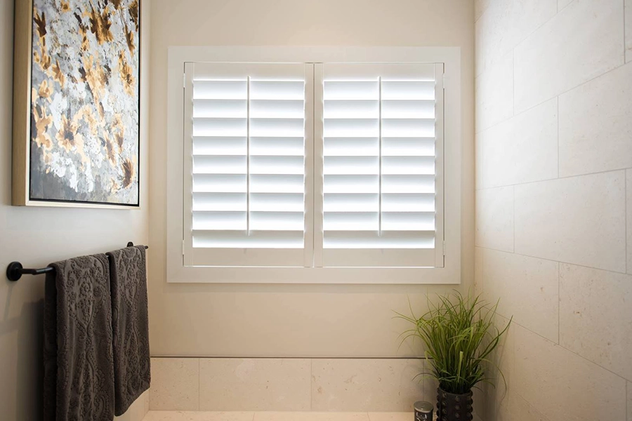 When in doubt, install long-lasting Polywood shutters. They last decades even in humid bathrooms! White Polywood shutters on a bathroom window