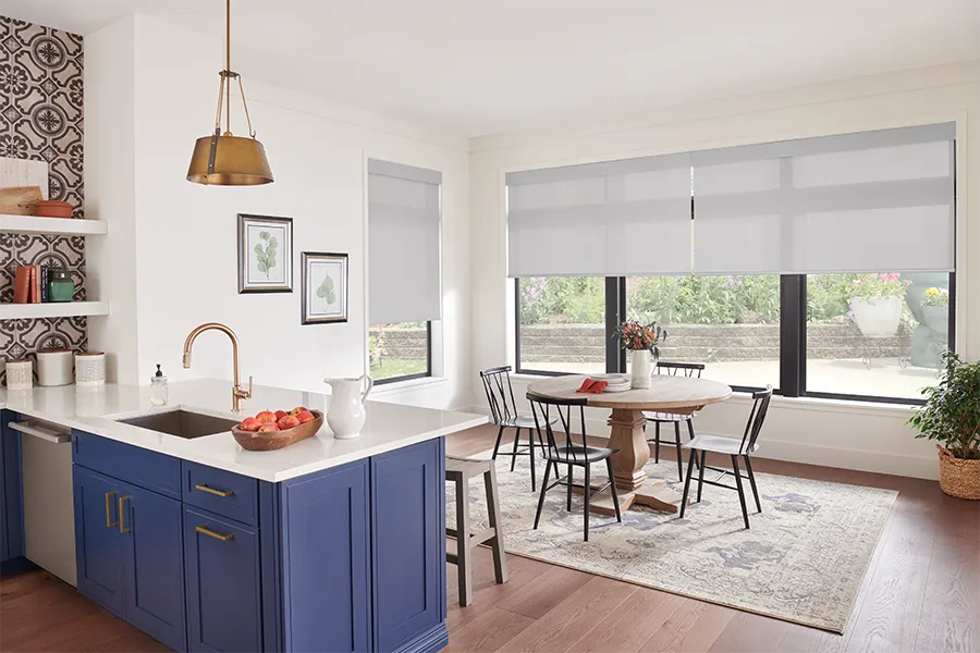 Light gray solar motorized shades within a kitchen and breakfast nook